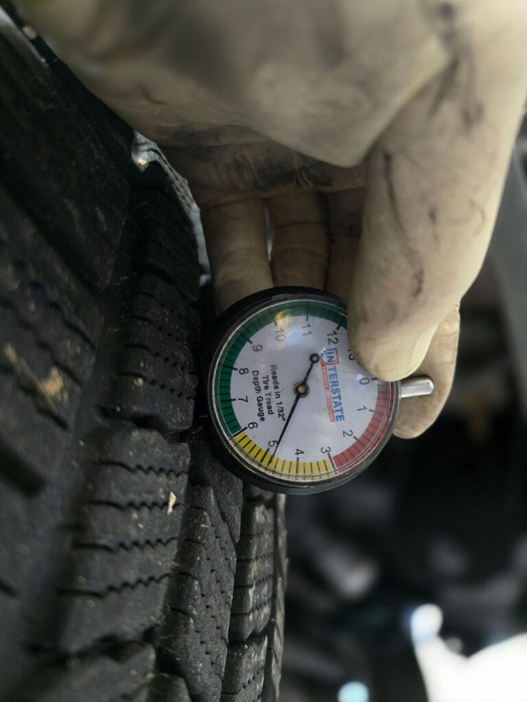 close up of tire gauge in a tire Smoky Hill Auto Service