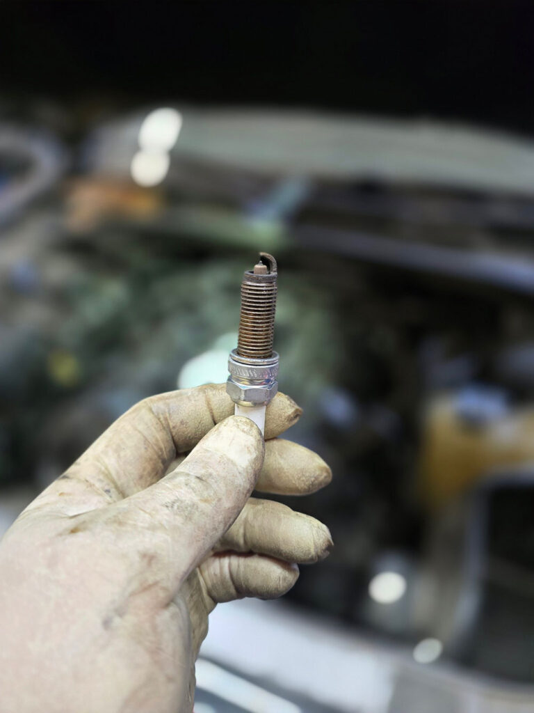 close up of mechanic holding spark plug Legacy Auto Clinic Castle Rock 