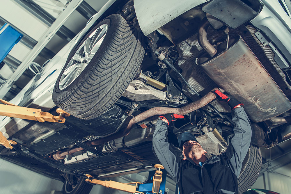 mechanic inspects vehicle exhaust system Legacy Auto Clinic Castle Rock 