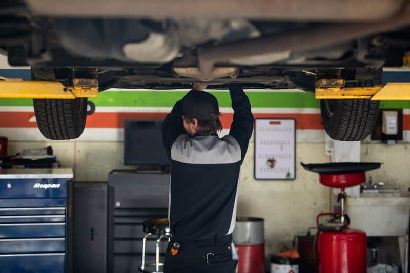 mechanic works under a vehicle to inspect and repair Legacy Auto Clinic Castle Rock 
