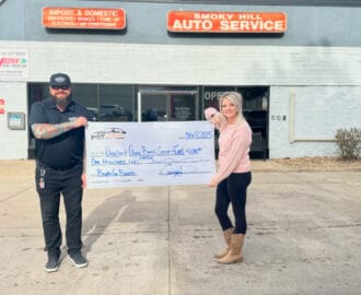 owners of Smoky Hill Auto and Legacy Auto proudly display donation check